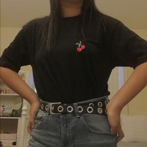 A black tee shirt with a cherry embroidered